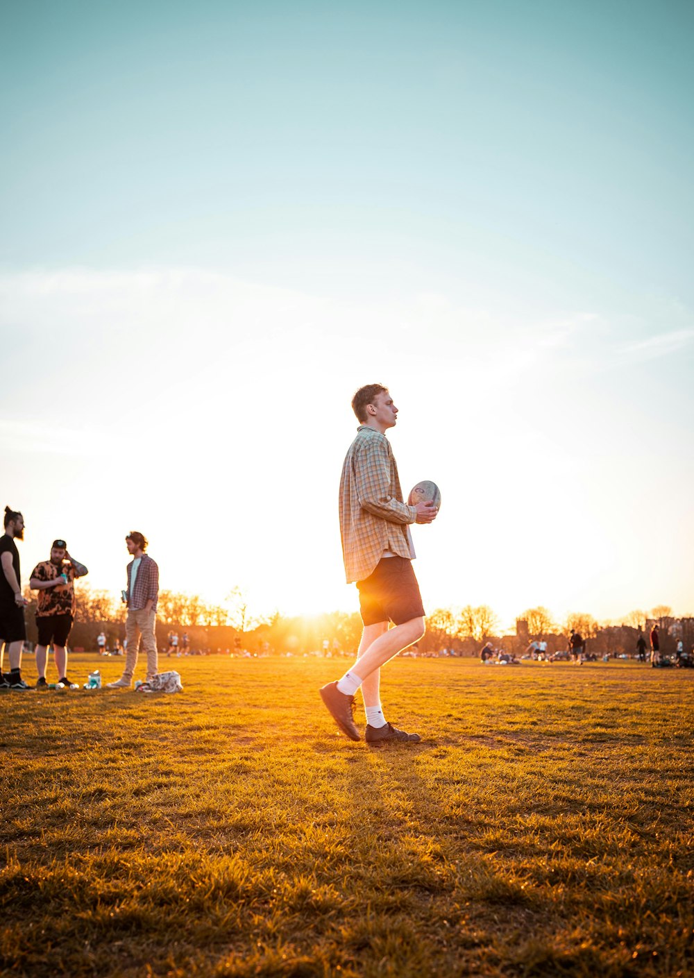 man in white t-shirt and black shorts running on field