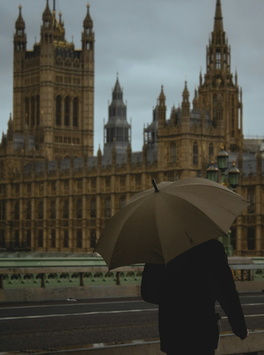 person holding umbrella standing near building during daytime