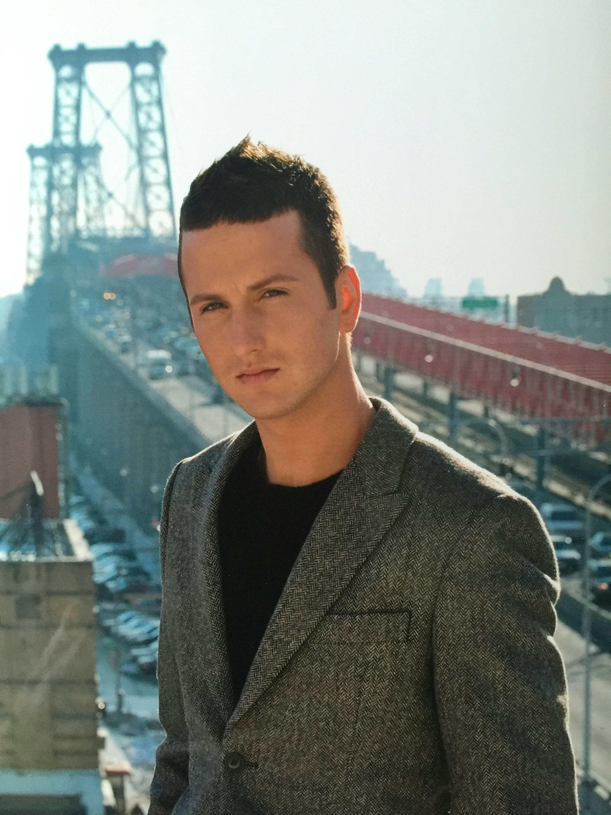 man in brown suit jacket standing on top of building during daytime