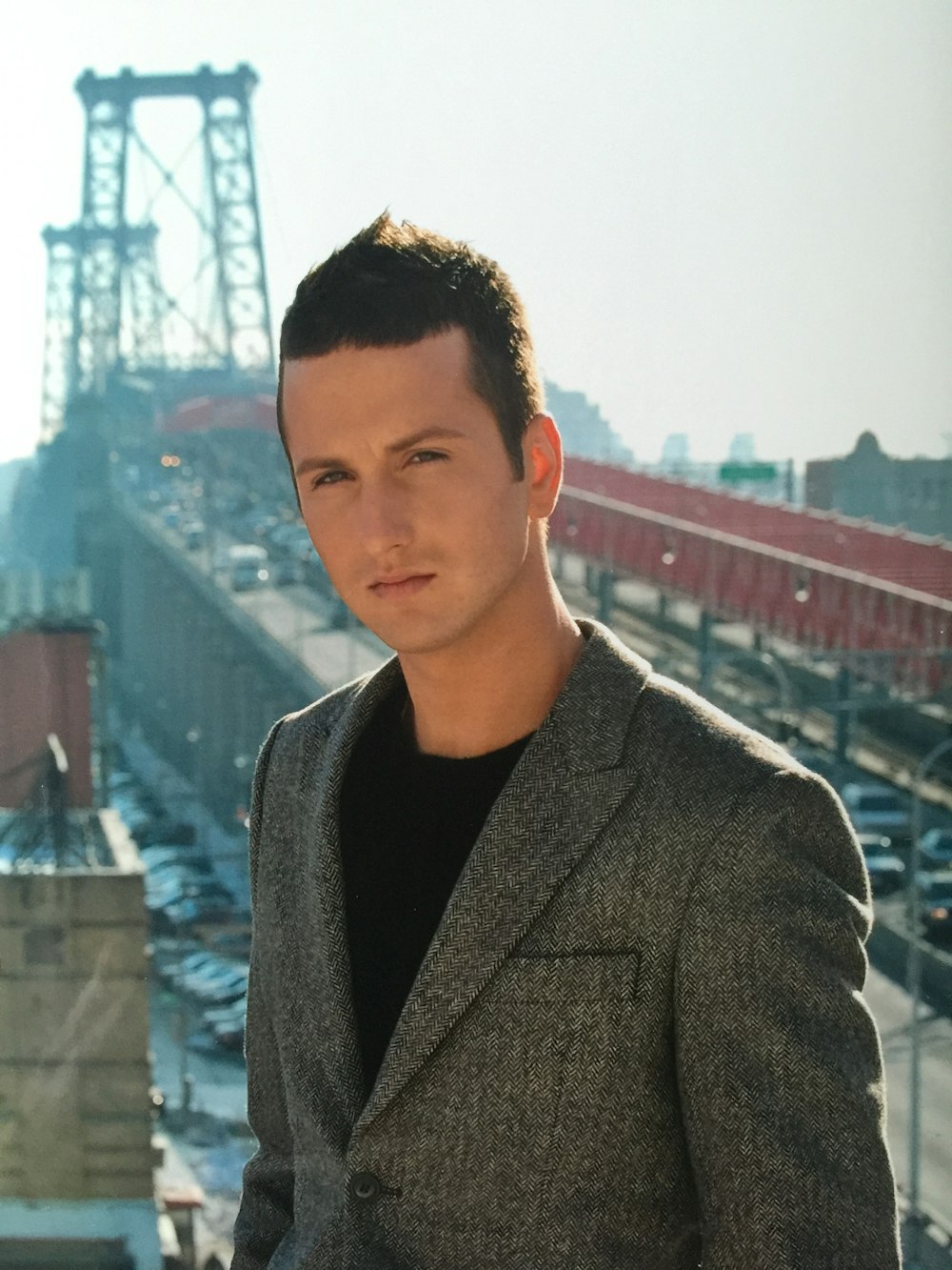 man in brown suit jacket standing on top of building during daytime