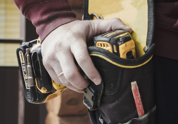 person holding black and yellow nike gloves