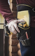 person holding black and yellow hand tool