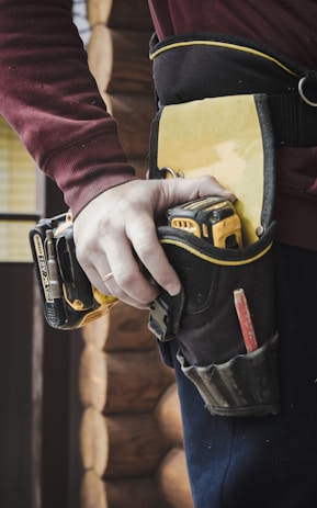 person holding a dewalt drill in a tool pouch