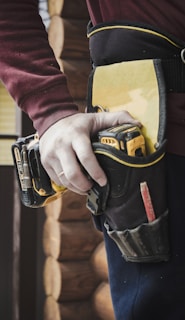 person holding black and yellow nike gloves