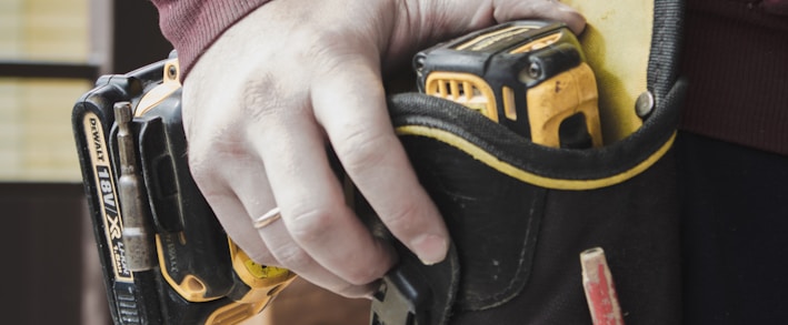 person holding black and yellow nike gloves