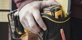 person holding black and yellow nike gloves