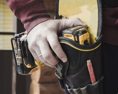 person holding black and yellow nike gloves