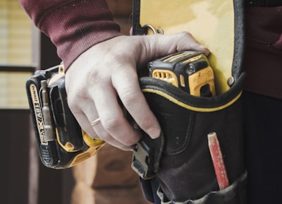 person holding black and yellow nike gloves