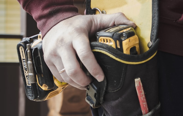 person holding black and yellow nike gloves