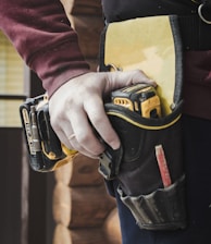 person holding black and yellow nike gloves