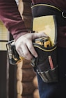 person holding black and yellow nike gloves