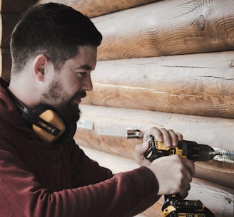 man in red long sleeve shirt holding black and yellow corded headphones