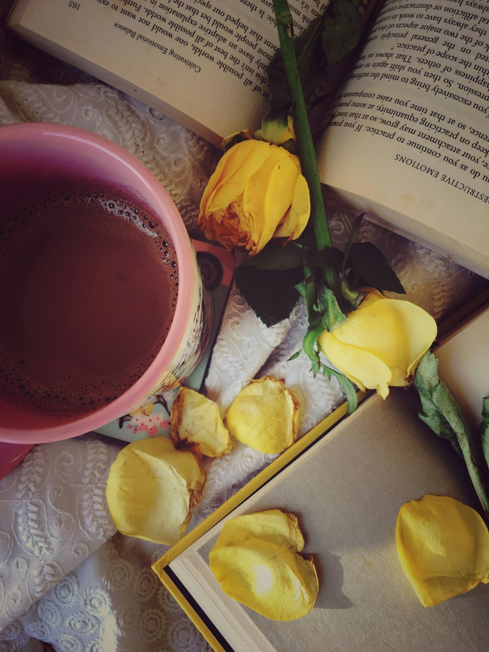 yellow roses beside red ceramic mug