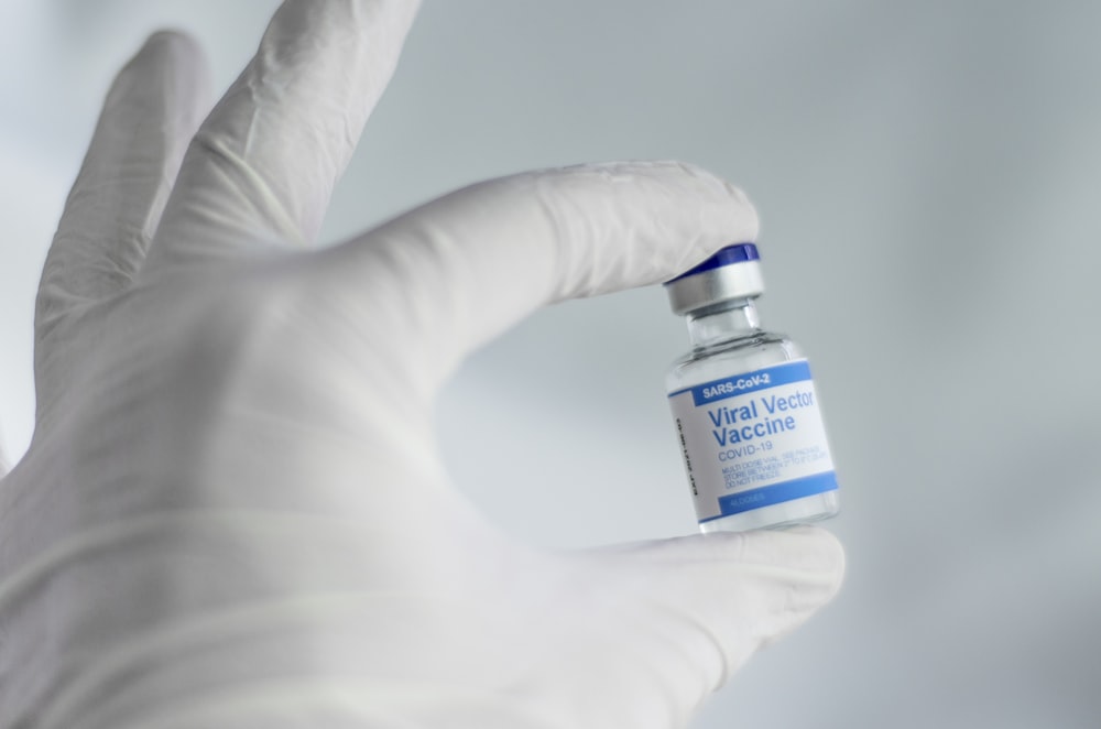 person holding white and blue labeled bottle