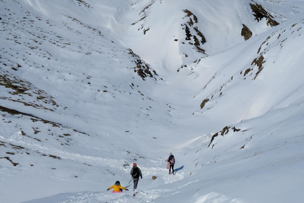 person in black jacket and blue pants walking on snow covered mountain during daytime