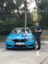 A professional driver standing next to a clean car ready to drive.