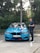 A satisfied customer standing next to a newly purchased car.