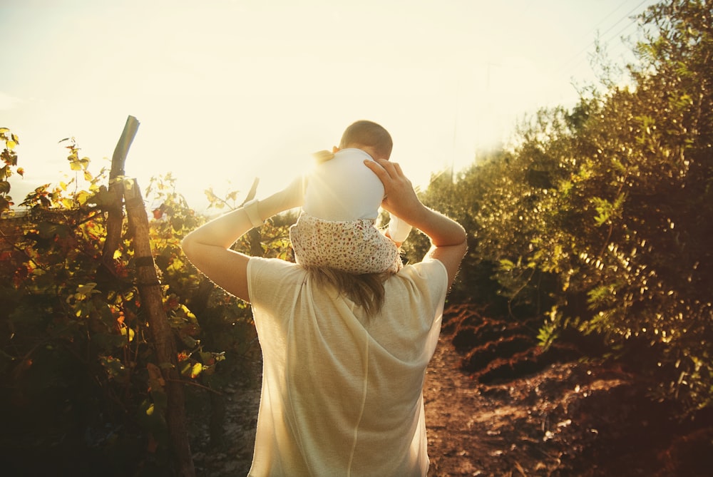 woman in white dress carrying baby in white dress