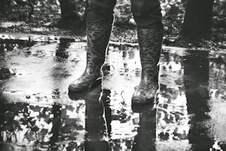 A pair of colorful rubber rain boots standing on a wet city sidewalk.