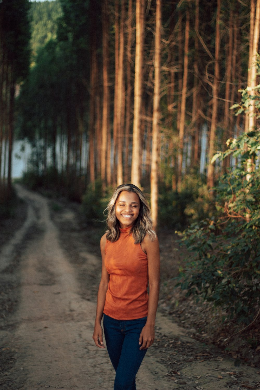 woman in brown tank top standing on dirt road