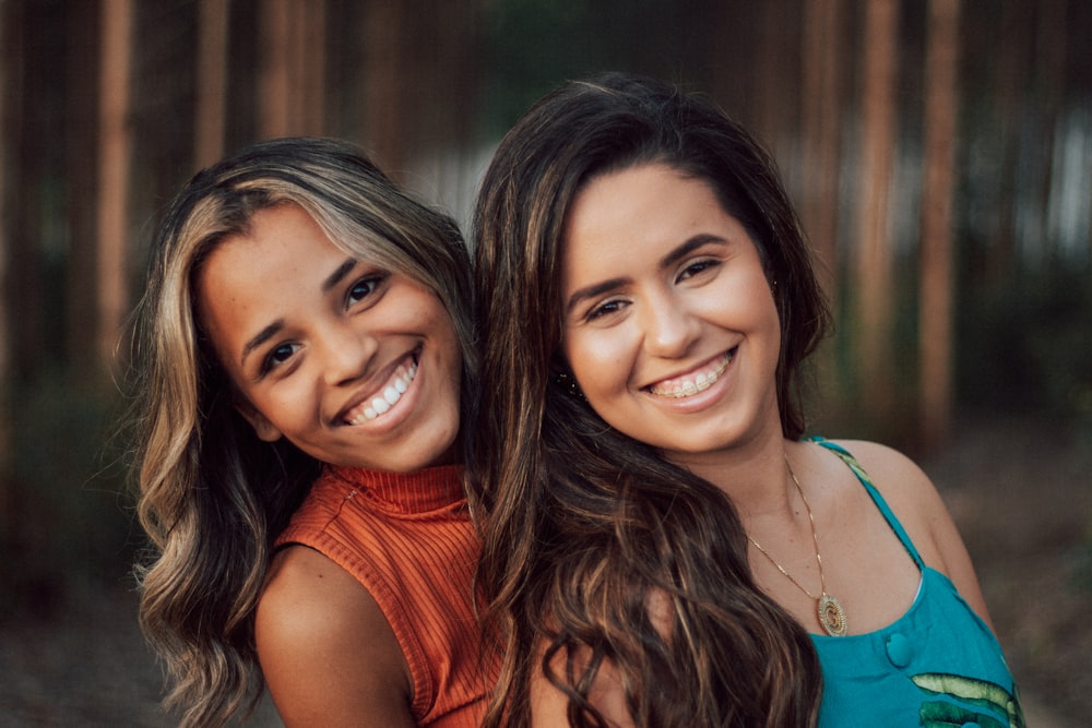 2 smiling women in orange tank top