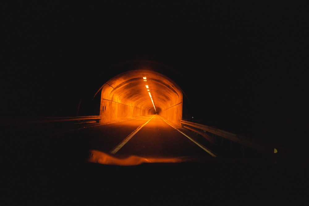 Person in schwarzer Jacke steht nachts im Tunnel