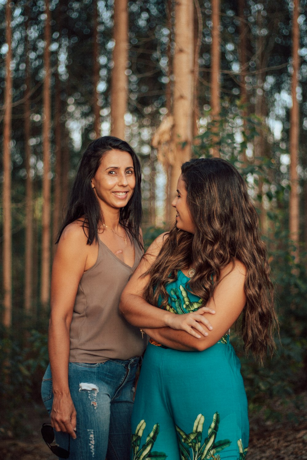 woman in blue tube dress hugging woman in green tube dress