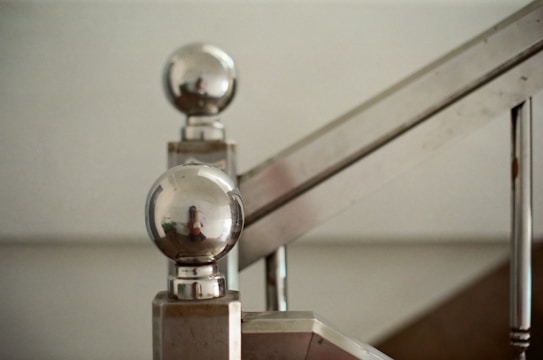 Close-up of a polished stainless steel hand rail installed on a staircase.