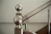 Close-up of a sleek metal spiral staircase with a polished stainless steel handrail.