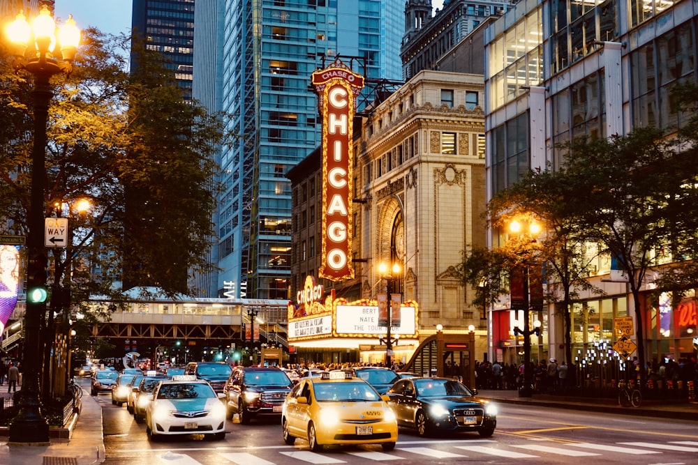 cars parked on street near high rise buildings during night time