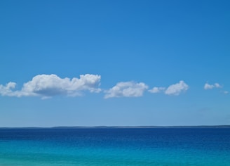 A serene ocean view with deep blue waters and a clear sky.