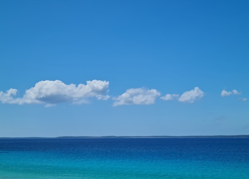 A serene ocean view with deep blue waters and a clear sky.