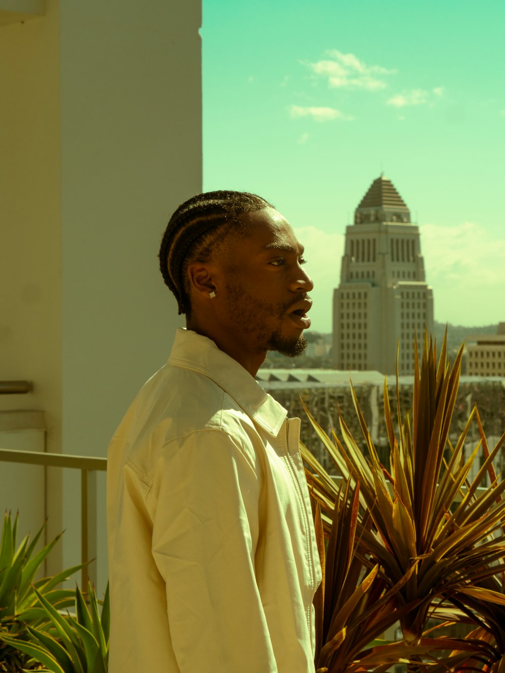 man in white dress shirt standing near green plant during daytime