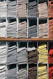white and yellow textiles on brown wooden shelf