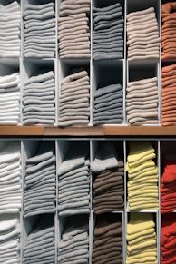 white and yellow textiles on brown wooden shelf