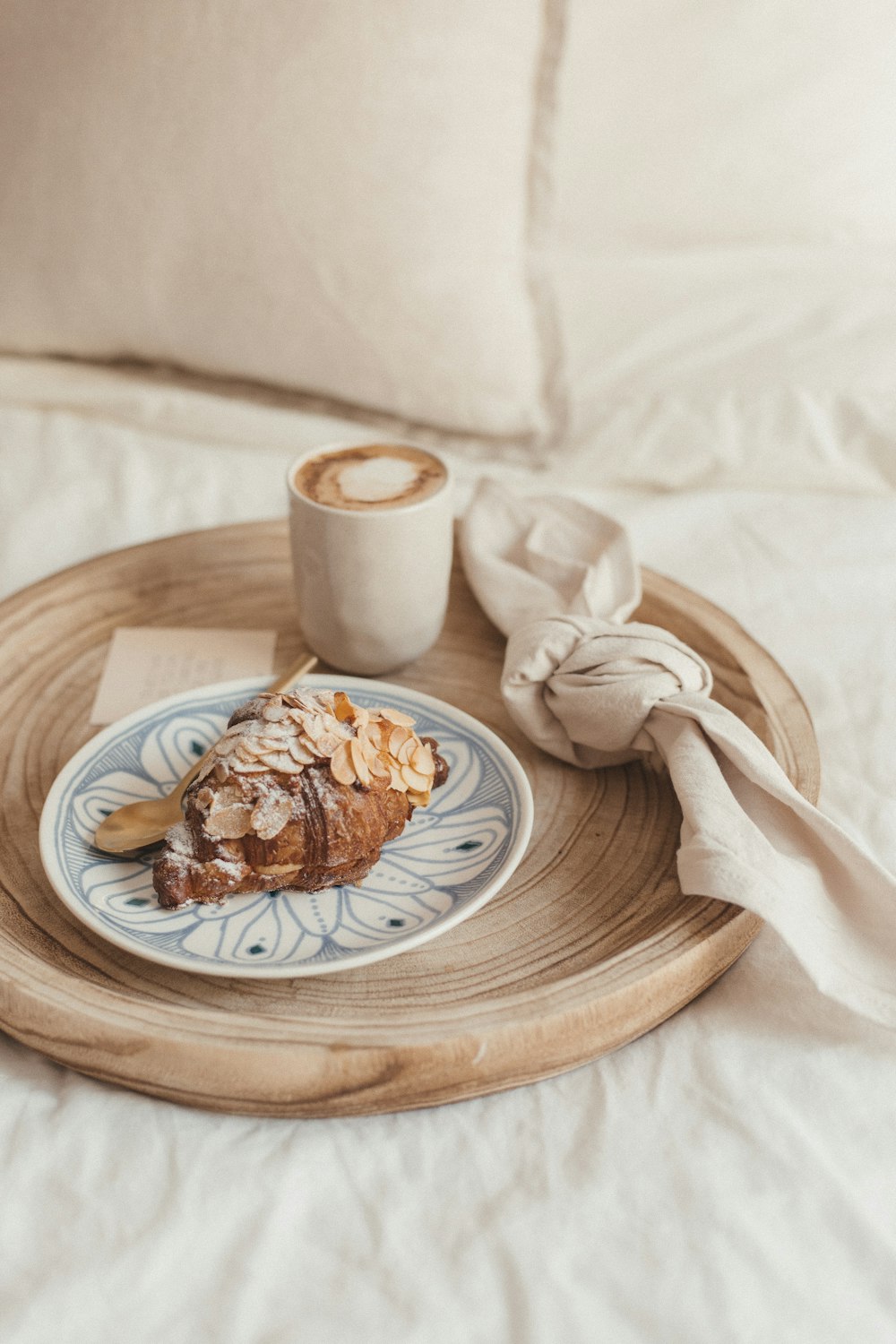 pain brun sur assiette en céramique blanche à côté d’une tasse en céramique blanche sur une table en bois brun