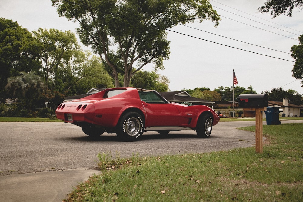 red classic car parked on the side of the road