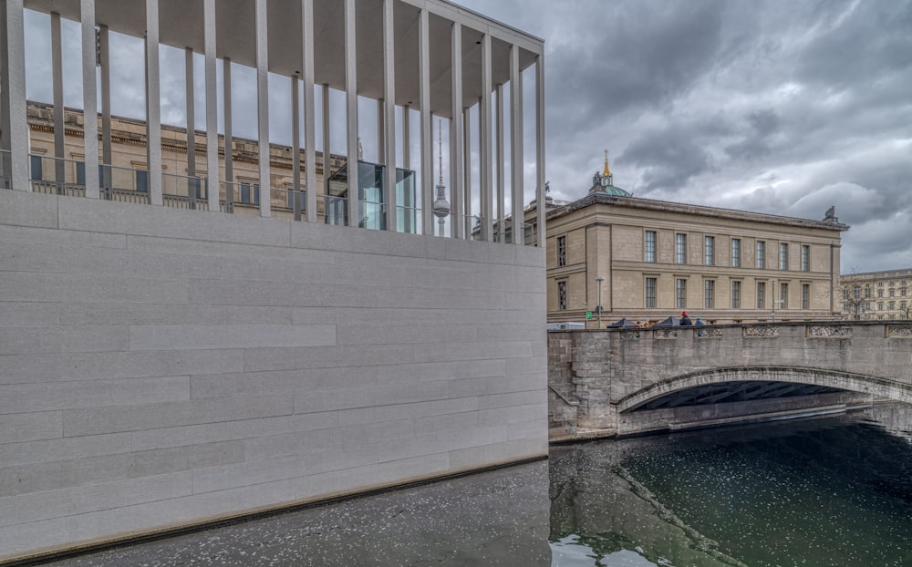 white concrete building near river under cloudy sky during daytime