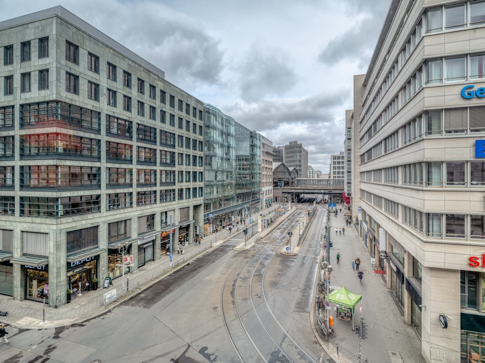 cars on road between high rise buildings during daytime