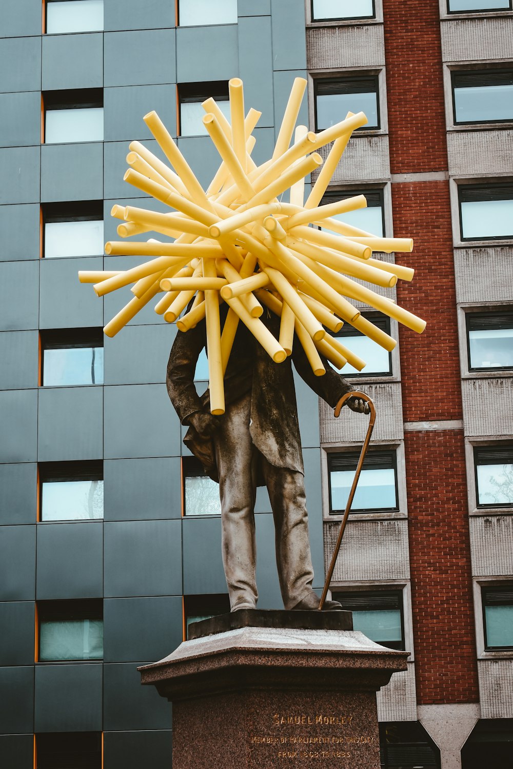 brown concrete statue of man holding stick