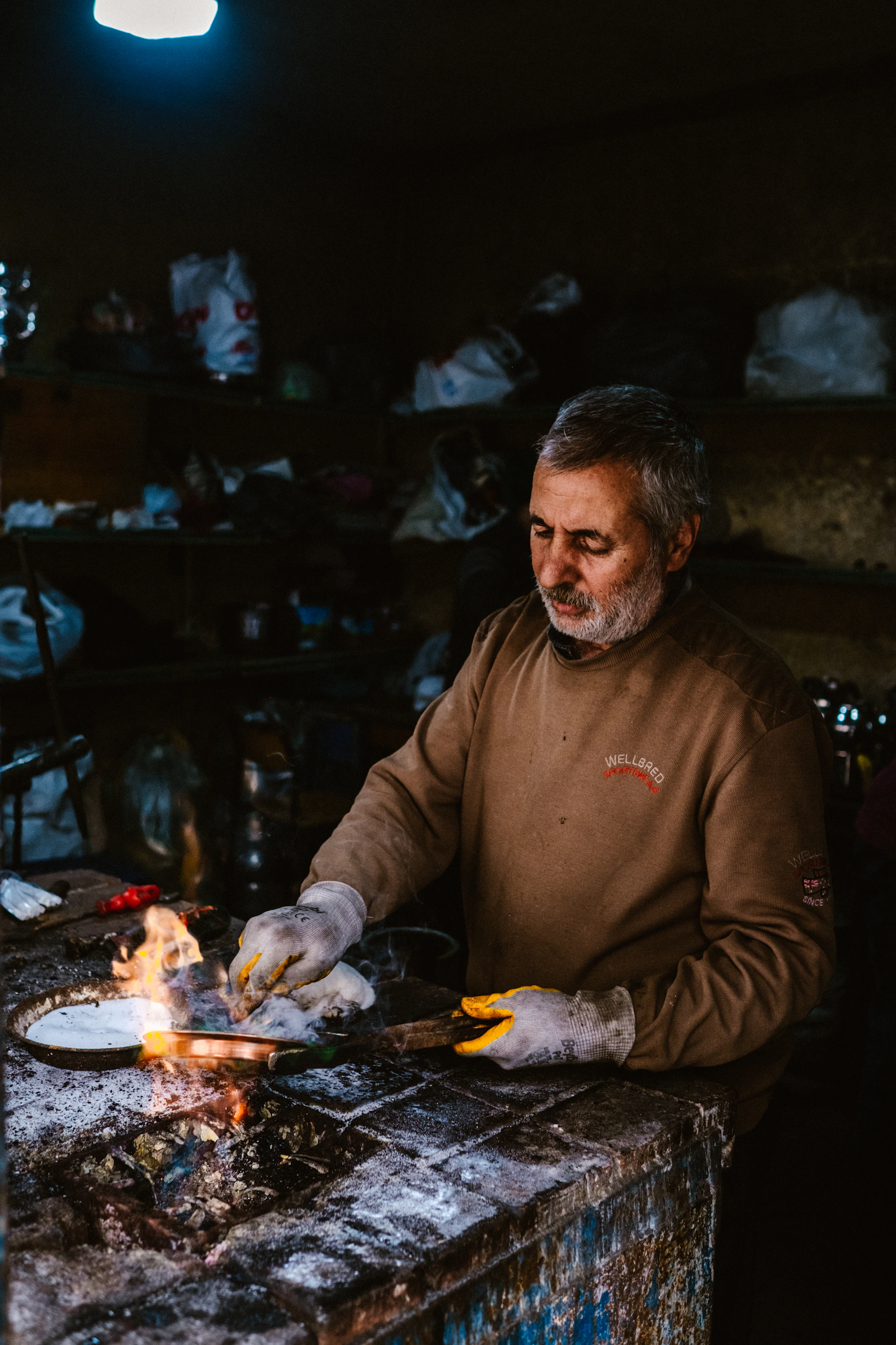 man in brown sweater holding knife and fork