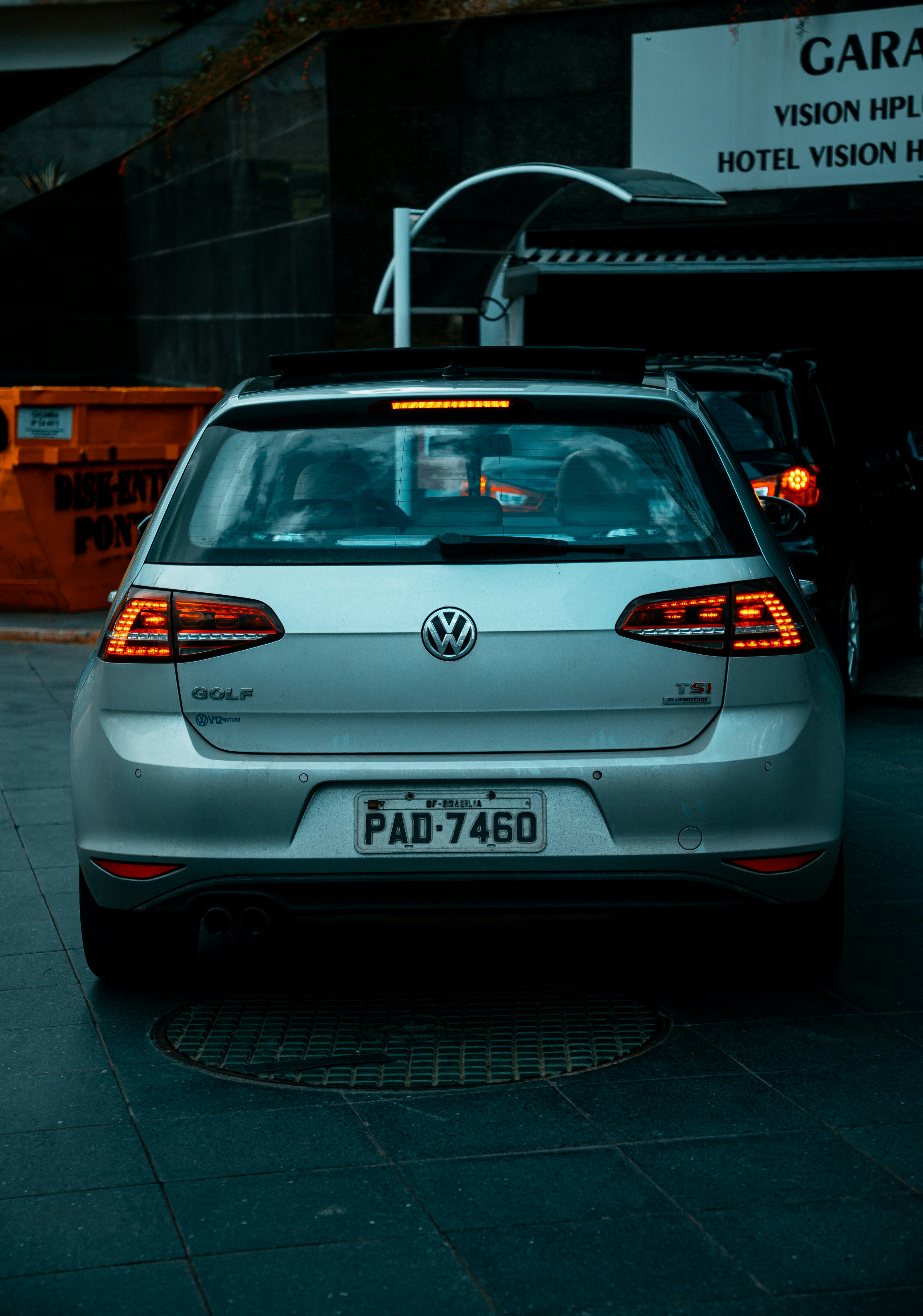 Weißes Volkswagen Auto parkt nachts auf Bürgersteig