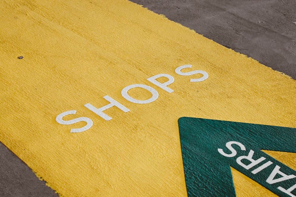 yellow and green sign on floor of car park