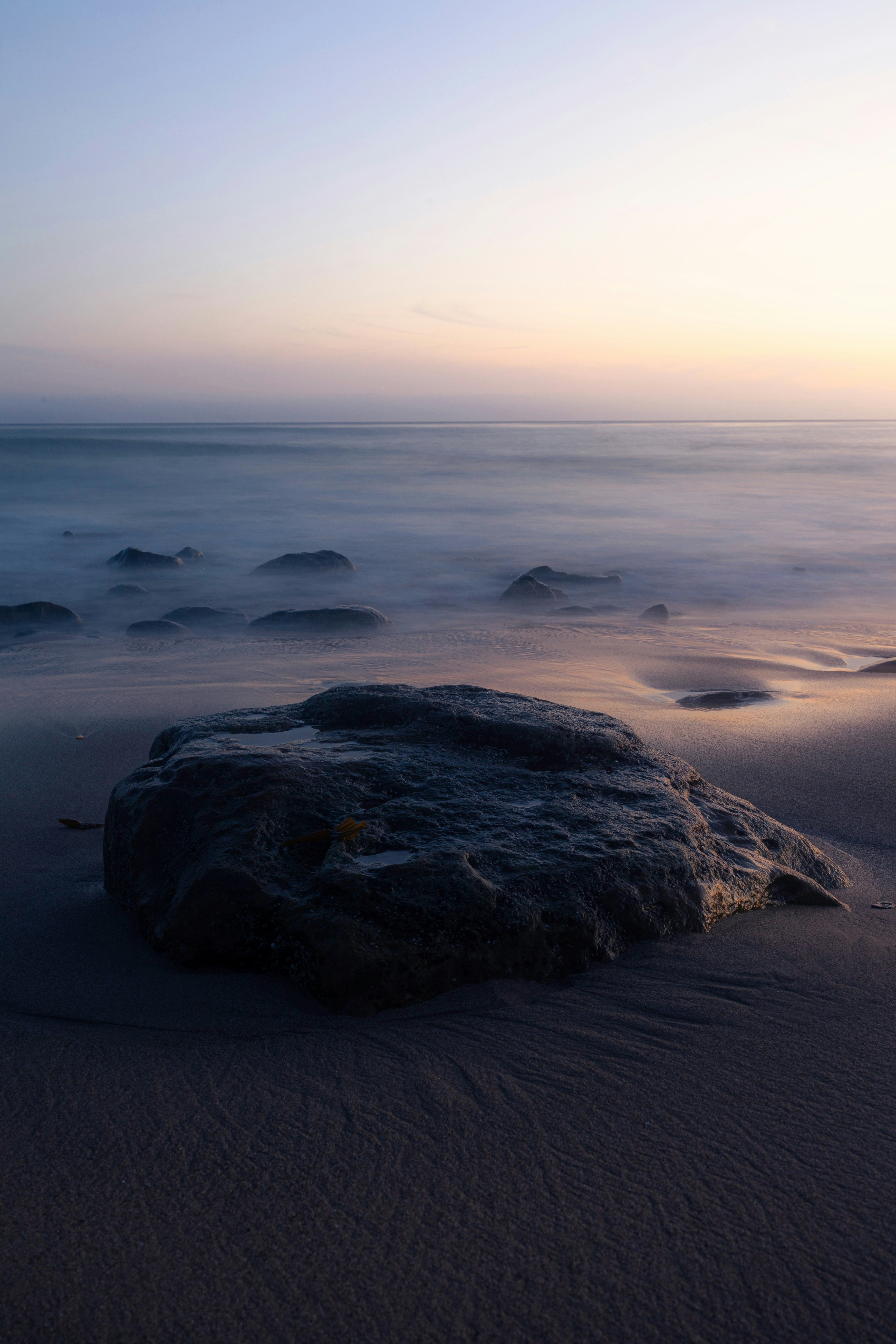 black rock formation on sea shore during daytime