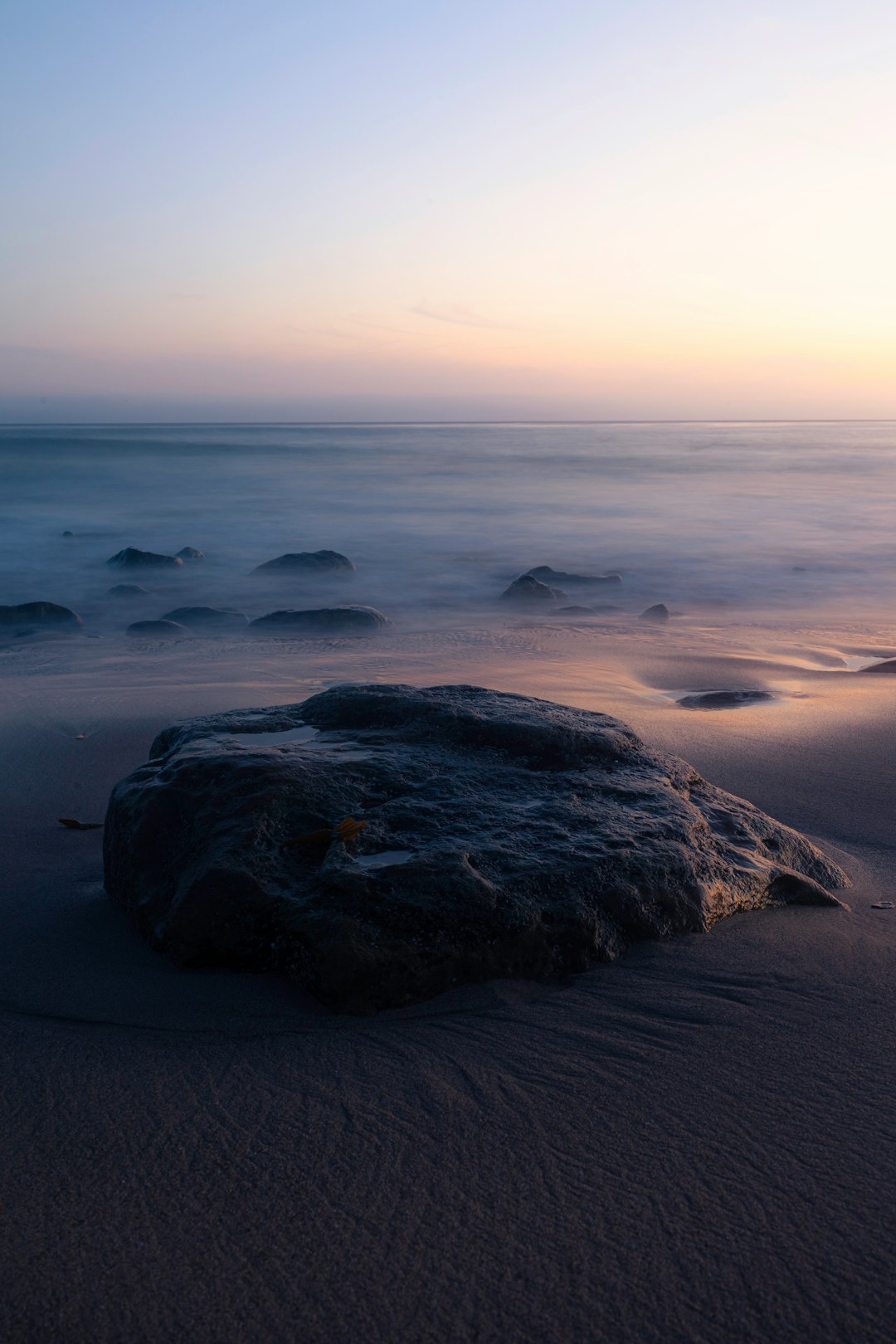 black rock formation on sea shore during daytime