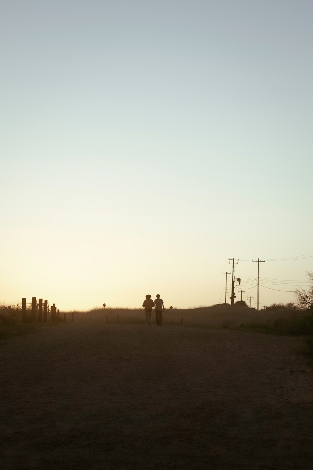 2 person walking on brown field during daytime