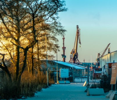 Wide view of a large industrial facility with cranes and heavy machinery in operation at sunrise.
