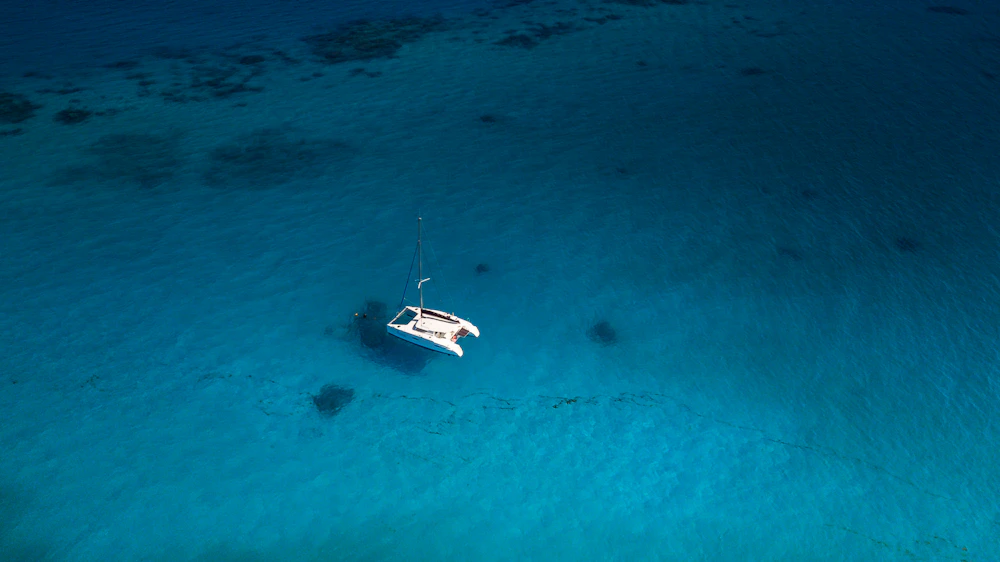 Aerial view of a small catamaran on deep blue water