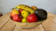 Fresh tropical fruits arranged beautifully on a rustic wooden table in a Colombian kitchen.