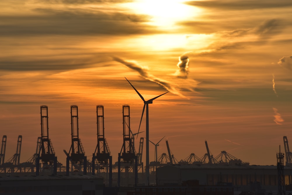 silhouette of wind turbines during sunset